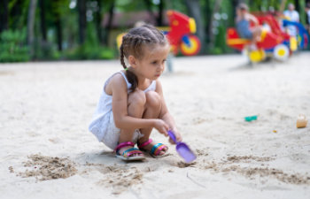 little girl playing sandbox playground